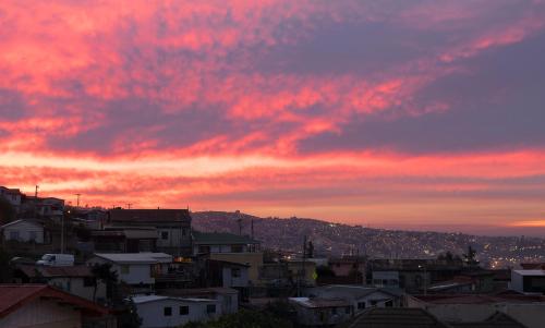 a sunset over a city with houses and buildings at Pontoval B&B in Valparaíso