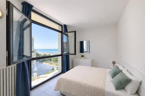 a bedroom with a bed and a large window at AMA Marena Apartments in Pesaro