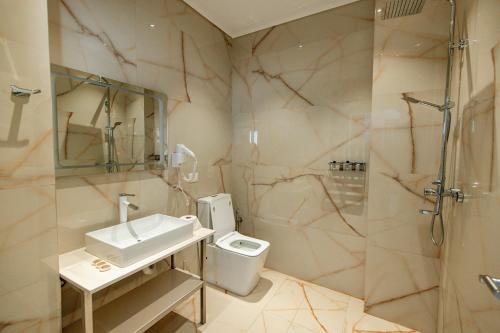 a bathroom with a toilet and a sink and a shower at Oxygen Boutique Hotel in Tirana