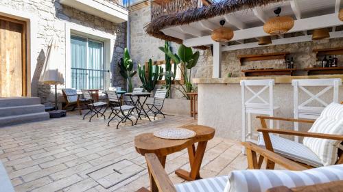 a patio with chairs and tables and a bar at Moon Alaçatı adults only in Çeşme