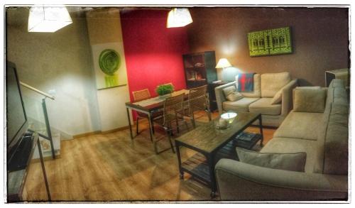 a living room with a couch and a table at Apartamentos Alcazar de Baeza in Baeza