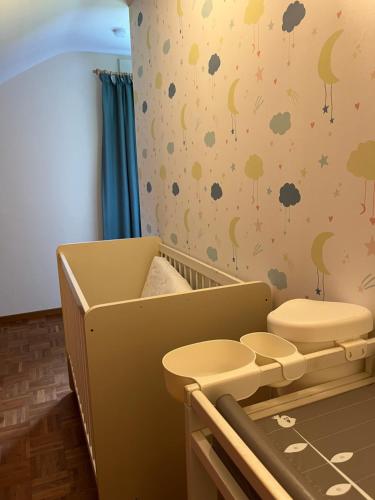 a nursery with a baby crib with clouds and trees at Vakantiewoning Pelterheggen in Grote Heide