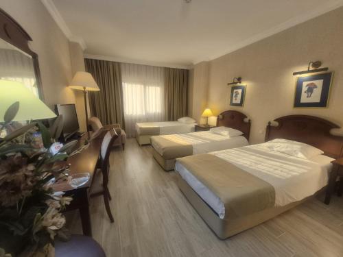 a hotel room with two beds and a desk at Büyük Sümela Otel in Macka