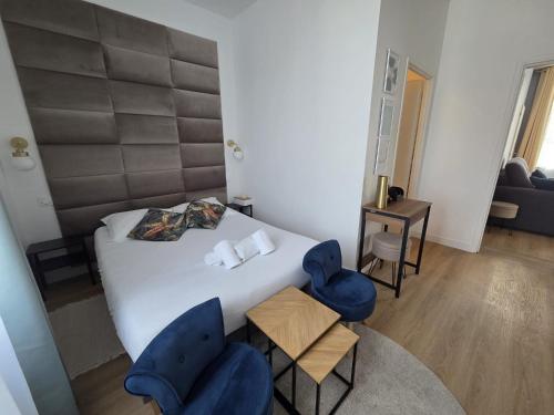 a bedroom with a bed and two blue chairs at G4 - Appartement 2 ch Climatisé Centre Angoulême in Angoulême