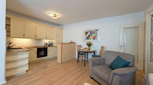 a living room with a couch and a table in a kitchen at FeWo Jette in Warnemünde