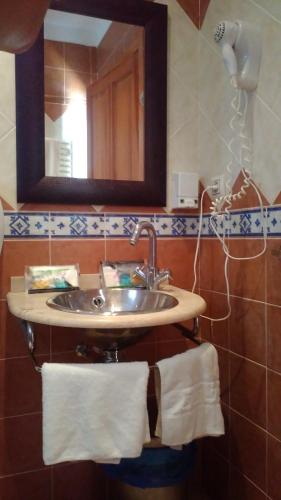 a bathroom with a sink and a mirror and towels at La Alberquilla in Yeste