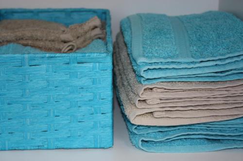 a stack of towels in a basket on a table at Vakantiewoning Cosy Corner in Ypres