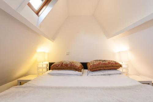 a bedroom with a white bed with two pillows at Design B&B Naarden Vesting in Naarden