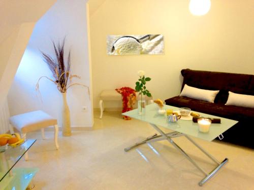 un salon avec un canapé et une table en verre dans l'établissement APPART'HOTEL61 Comme à la maison au Cœur de la Normandie, à Flers