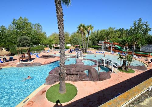 a pool at a resort with people swimming in it at Camping Les Salisses - Aquatique Vacances in Vias