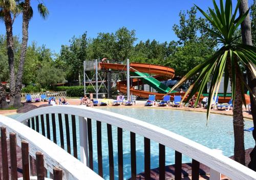 a pool with a slide at a water park at Camping Les Salisses - Aquatique Vacances in Vias