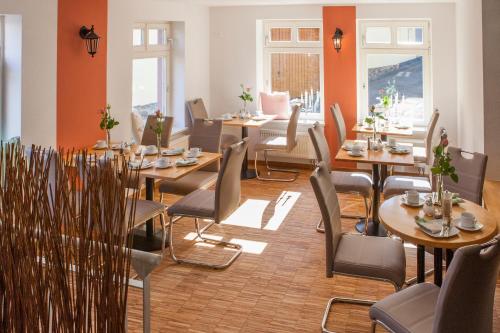 a dining room with tables and chairs and windows at Hotel am Markt in Hungen