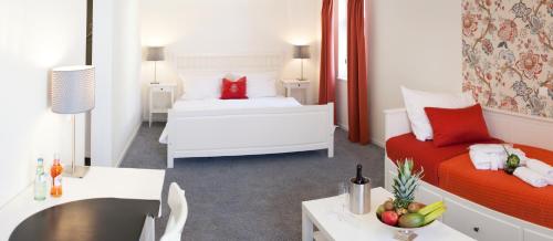 a hotel room with two beds and a table with a bowl of fruit at Hotel am Markt in Hungen