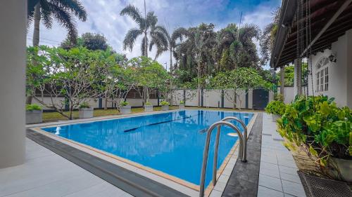 a swimming pool with blue water in a building at Eco Villa Resort in Negombo