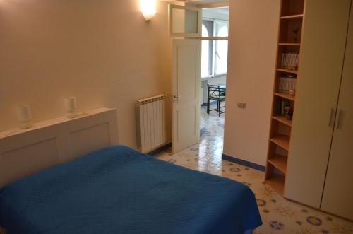 a bedroom with a blue bed and a book shelf at Casa Cecilia in Ravello