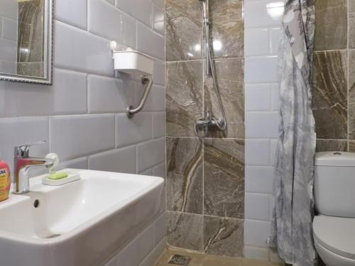 a bathroom with a sink and a shower and a toilet at Tekrour- la case des hôtes- Suite privée-chambre, salon et cuisine complete in Mbour