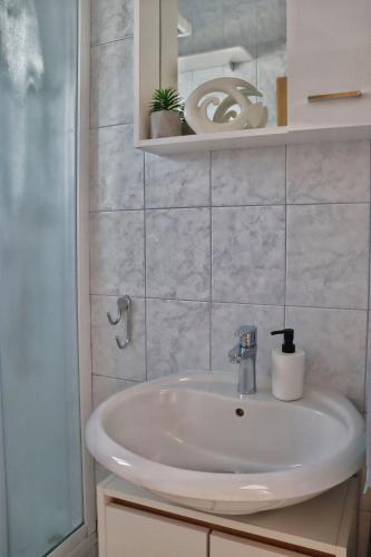 a bathroom with a white sink and a mirror at Apartment Elena in Sumartin