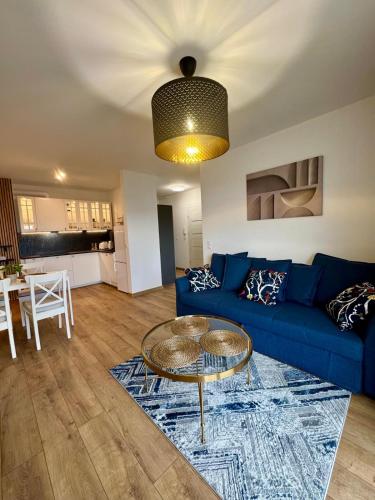 a living room with a blue couch and a table at Apartament Perła Łagowa in Łagów