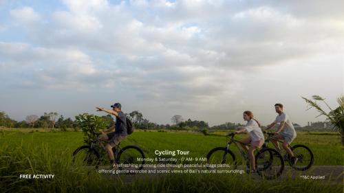 a group of three people riding bikes in a field at Sanctoo Suites & Villas in Gianyar