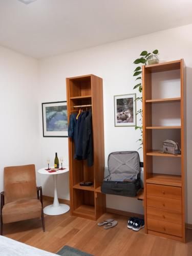 a bedroom with a book shelf and a chair and a table at Enoturismo Dofinè in Due Carrare