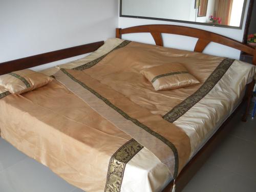 een slaapkamer met een bed met een houten frame bij Beachfront Cozy Studio in Ban Phe