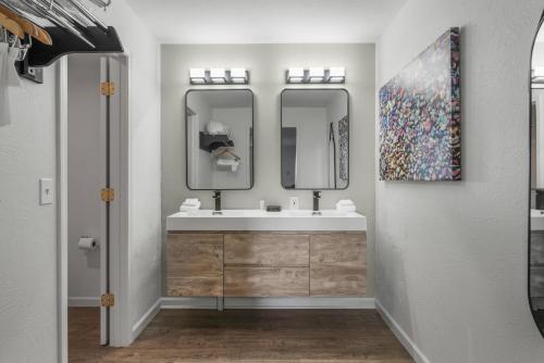 a bathroom with a sink and two mirrors at Americas Best Value Inn Polson in Polson
