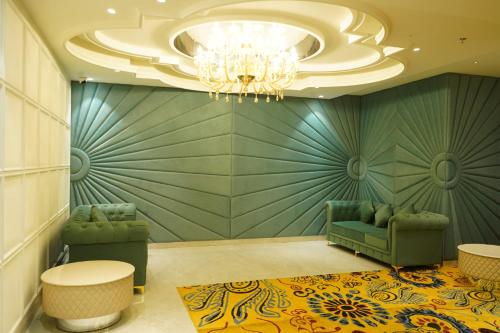 a lobby with green furniture and a chandelier at Hotel Pacific Primee in Zirakpur