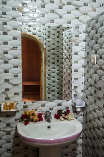 Aït BoukhaにあるMaison Nomadesの洗面台と鏡のあるバスルーム