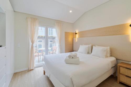a bedroom with a large white bed with two teddy bears on it at Setúbal Serenity Villa II, By Home Match in Setúbal