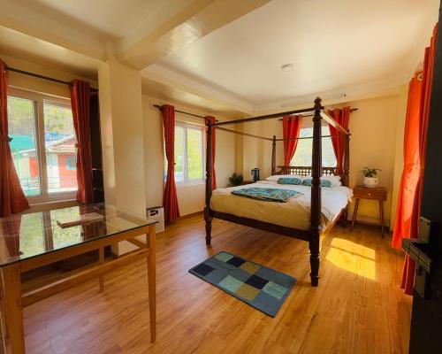 a bedroom with a four poster bed and a glass table at Perched on a mountain top, breathtaking city view in Kathmandu