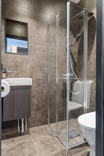 ein Badezimmer mit Dusche, Toilette und Waschbecken in der Unterkunft Strandgata Hotel in Haugesund