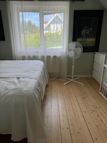 a bedroom with a bed and a fan and a window at Dalagård i Insjön in Insjön