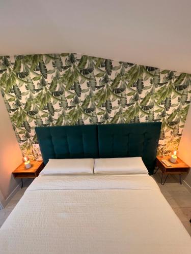 a bedroom with a bed with a green head board at Villa Meraki experiencia in San Miguel de Corneja