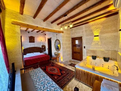 ein Badezimmer mit Bett und Badewanne in einem Zimmer in der Unterkunft Avanos Suites in Avanos