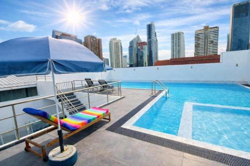 a pool with a lounge chair and an umbrella at Harmony Living Condominium in Makkasan