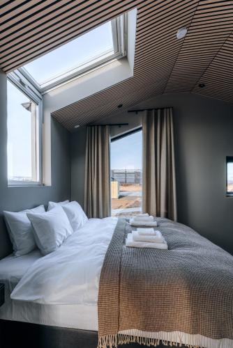 a bedroom with a large bed with a window at Green Geysir Cottage in Torfastaðir