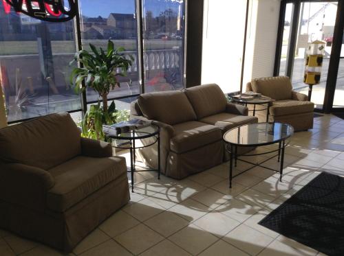 a living room with couches and tables and windows at Ocean View Inn in Norfolk