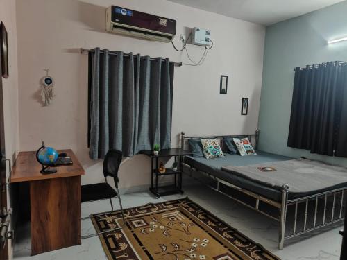 a bedroom with a bed and a table and a desk at The Human Nest Coliving in Bhubaneshwar