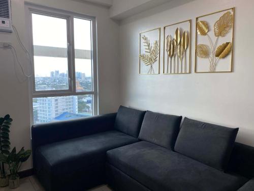 a living room with a blue couch and a window at Gradient Sky in Manila