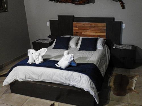 a bedroom with a bed with two stuffed animals on it at Mazuri Shamba Lodge in Phalaborwa