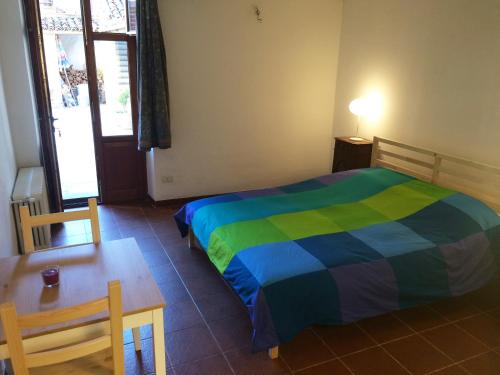 una camera da letto con un letto, un tavolo, un tavolo e delle sedie di Villa Maddalena a Bra