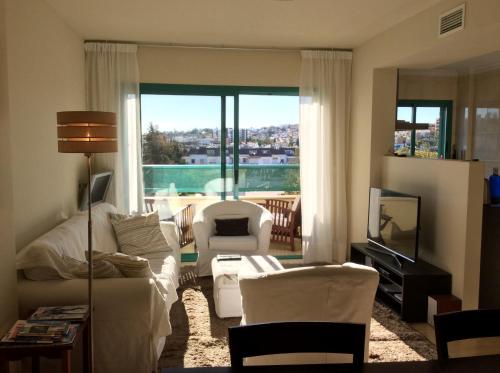 a living room with a couch and chairs and a television at Casa Toboso 2 in Torre del Mar