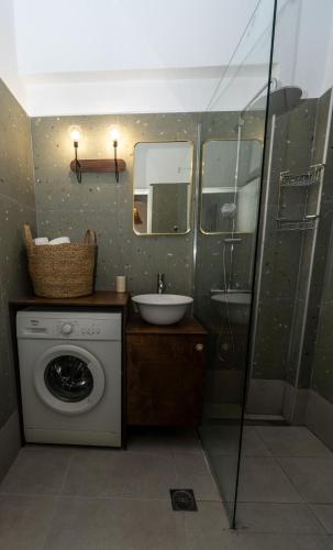 a bathroom with a washing machine and a sink at Salla Chiotis in Karpathos