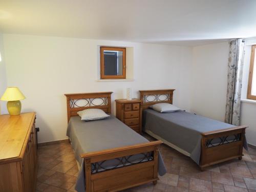 1 dormitorio con 2 camas, mesa y espejo en campagne de pimayon, en Manosque