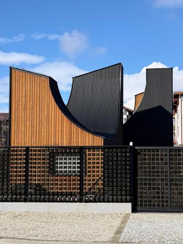 a building with a fence in front of it at Three Peaks Thermal Villas in Banya