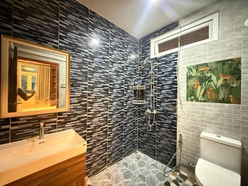 a bathroom with a toilet and a sink and a shower at Sufficient House in Nong Prue