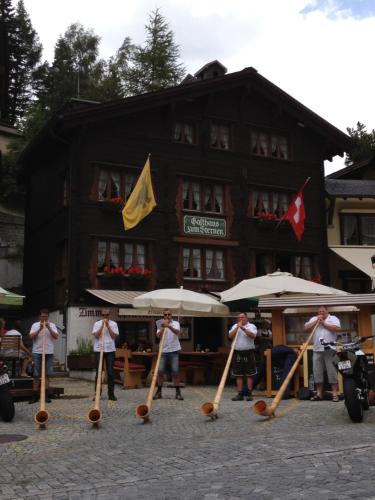 a group of people standing in front of a building with umbrellas at Gasthaus zum Sternen in Andermatt