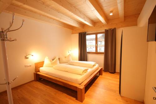 a bedroom with a bed and a large window at Großglockner Goldried Chalet in Kals am Großglockner