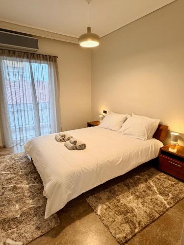 a bedroom with a large white bed and a window at B2 Pausilipon Park Corner in Karditsa