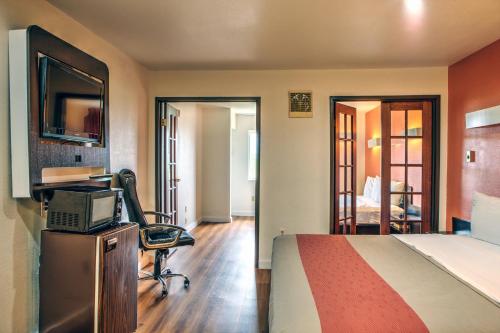 a hotel room with a bed and a desk and a computer at Motel 6-Dallas, TX - Northwest in Dallas